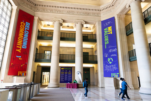 Image inside of the MIT rotunda where two banners hang. The red banner reads belonging and community. The Blue banner reads MIT Values