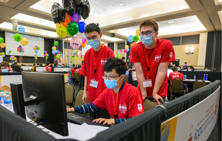 Sharing a single computer, Ziqian Zhong, MingYang Deng, and Anton Trygub work on their coding solution.