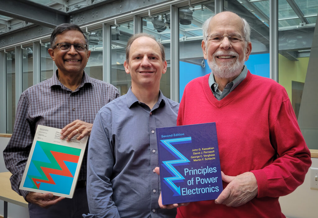 From left to right: George Verghese, David Perreault, and John Kassakian pose with a copy of their new textbook, Principles of Power Electronics (2nd edition).